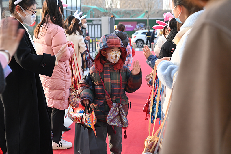 2月13日,昌平區北京十一未來城學校的老師們歡迎同學們回到校園,他們給每位學生都挂上一個福袋,希望把一年的福氣都送給學生們。昌平區北京十一未來城學校供圖