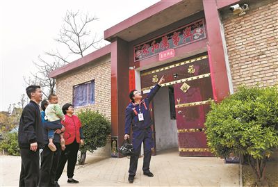 在山西省运城市平陆县郭原村，宽带维护工作人员（右一）向村民介绍智能家居摄像头的功能。新华社记者 柴婷摄